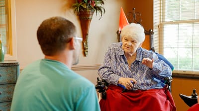 A resident engaging in conversation with a staff member