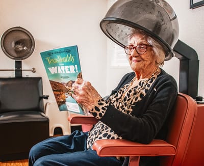 Senior resident enjoying salon treatment with a magazine