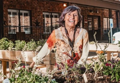 Resident smiling in a garden area