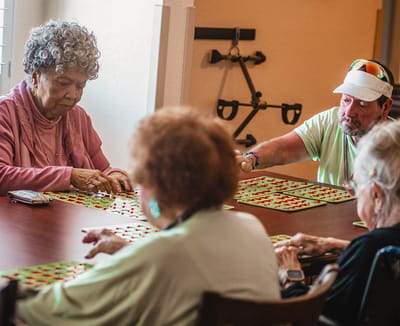Residents playing bingo in a social activity room