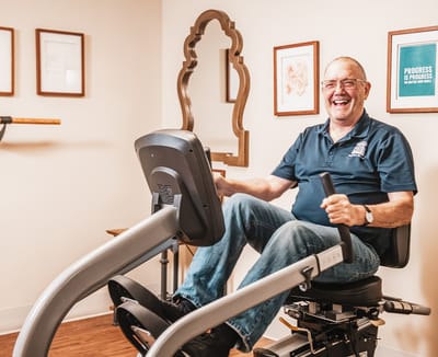 Resident exercising on a stationary bike in a bright room