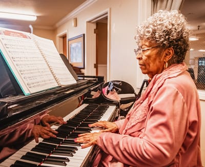 A resident playing the piano in a common area