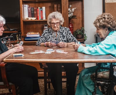 Residents playing cards in a cozy activity room