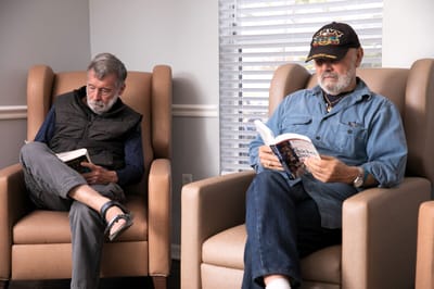 Two residents reading in a comfortable seating area