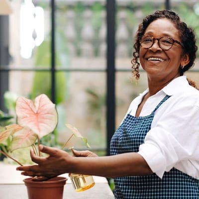 Resident tending to plants in an indoor space