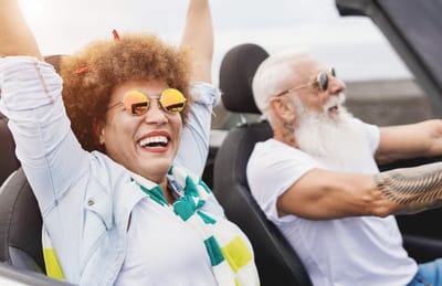 Two seniors enjoying a drive in a convertible