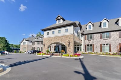 Exterior view of Orchard Senior Living facility with flowers and parking