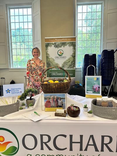 A staff member at an event table with promotional materials