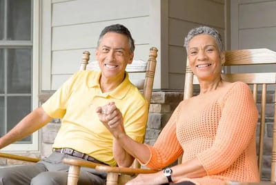 Two seniors enjoying rocking chairs on a porch