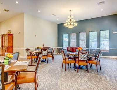 Bright dining room with tables and chairs set for residents