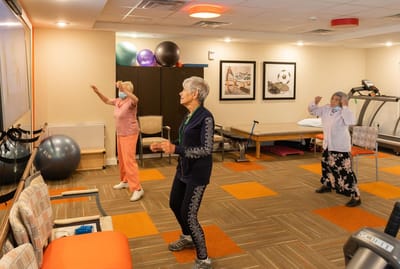 Residents participating in an exercise class indoors