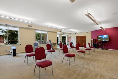 Bright activity room with chairs and exercise equipment