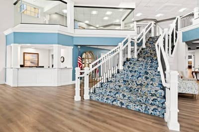 Bright interior lobby with a staircase and reception area
