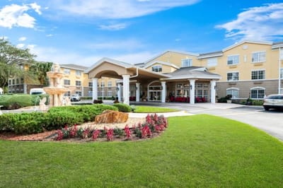 Exterior view of assisted living facility with fountain and landscaping