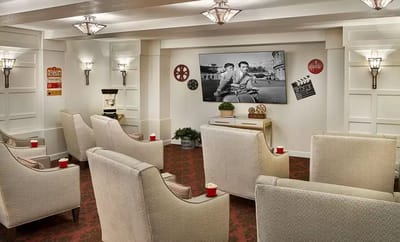 A cozy common area with comfortable seating and a movie screen