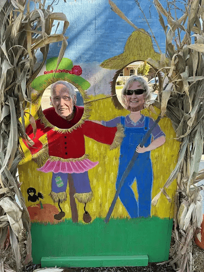 Residents posing happily at a festive backdrop
