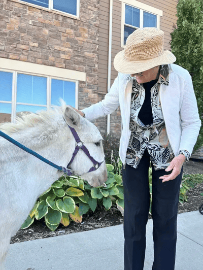 Resident interacting with a pony outside the facility