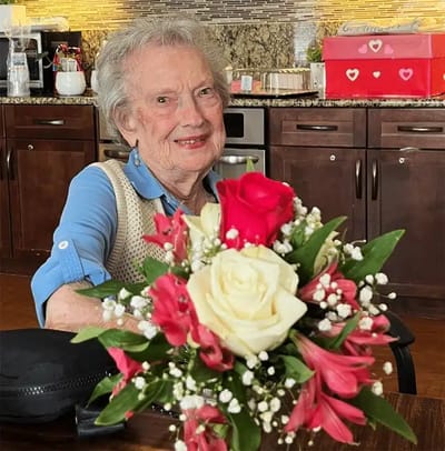 Resident holding a bouquet of flowers in a common area