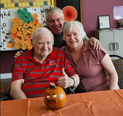 Residents celebrating with a pumpkin during an activity