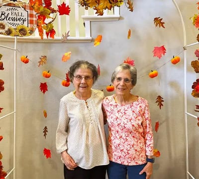 Two residents celebrating autumn in a decorated area
