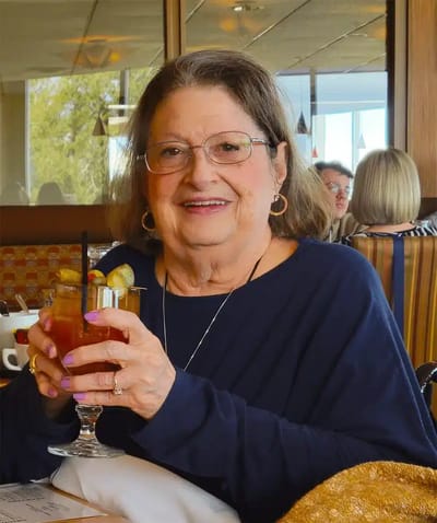 Senior resident enjoying a drink in a dining area