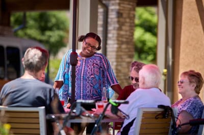 Residents engaging in conversation outdoors at the facility