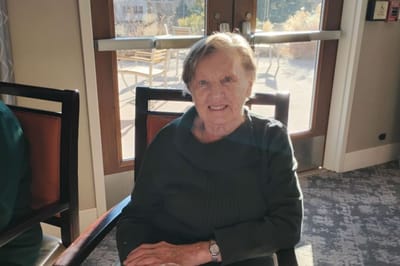A resident smiling while seated in a common area