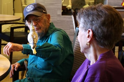A resident interacting with a bird in a social space
