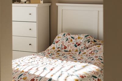 Cozy bedroom with floral bedding and white furniture