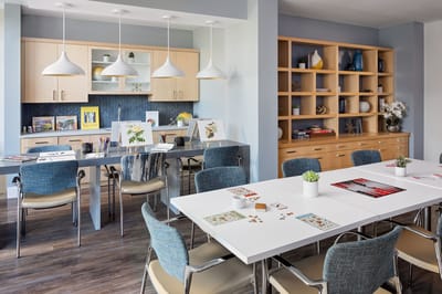 Interior view of a bright common area with tables and chairs