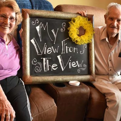 Residents posing with a sign in an interior setting