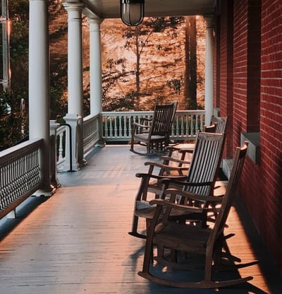 Rocking chairs on a porch with sunset lighting