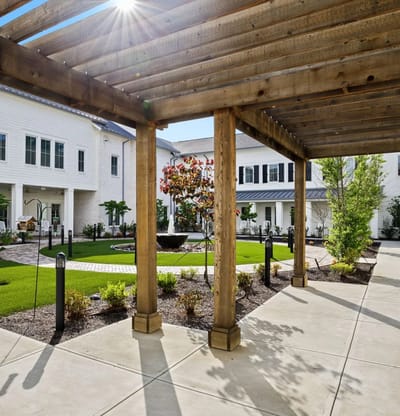 View of a courtyard with wooden pergola and landscaping