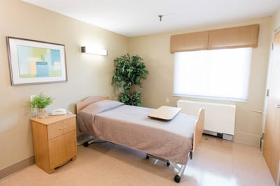 Bright private resident room with bed and furnishings