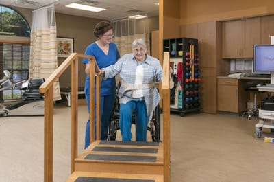 A staff member assisting a resident in a therapy area