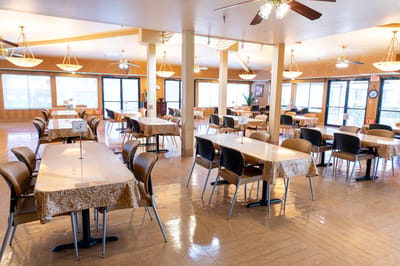 Dining area with tables and chairs set up for residents