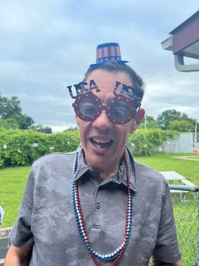 Resident celebrating with festive accessories outdoors.
