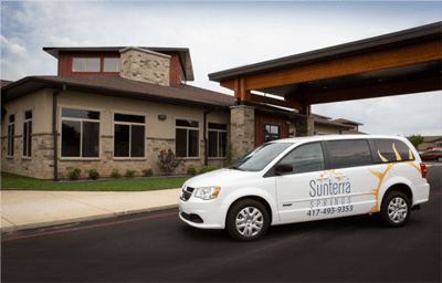Sunterra Springs building with facility vehicle parked outside.
