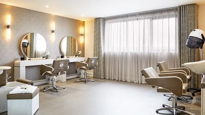 Well-lit beauty salon with modern styling chairs and mirrors.