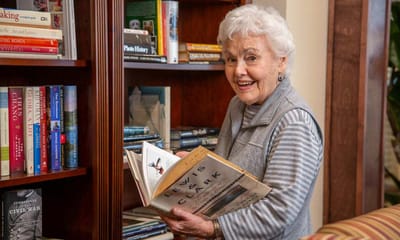 Senior woman enjoying a book in the library.