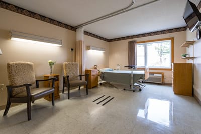 Private resident room with two chairs and a bed.