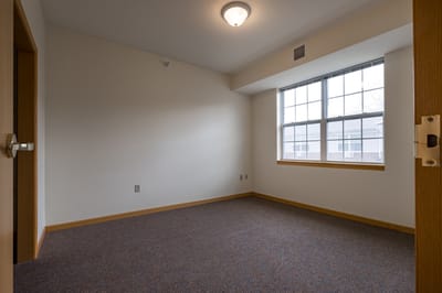 Empty resident room with a window and carpet