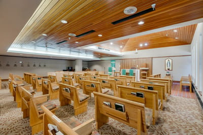 Interior view of a chapel with wooden pews