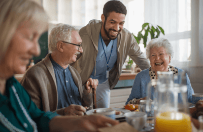 Residents enjoying a meal with staff member