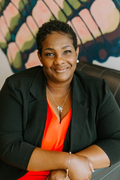 Portrait of a smiling woman in a colorful setting.