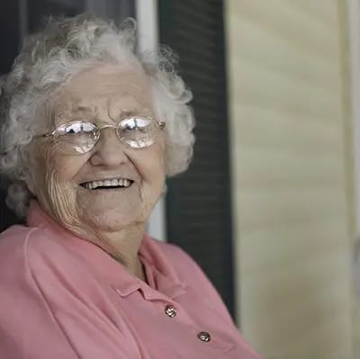 Senior woman smiling on a porch