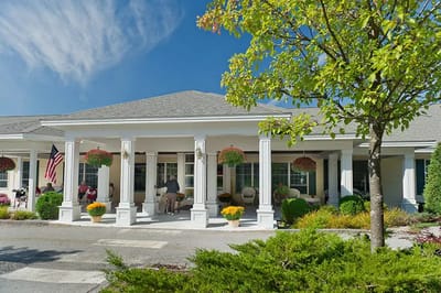 Exterior of Woodlands Senior Living with residents relaxing