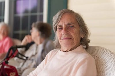 Smiling elderly woman sitting on a porch