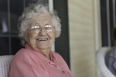 Smiling elderly woman in a pink shirt.