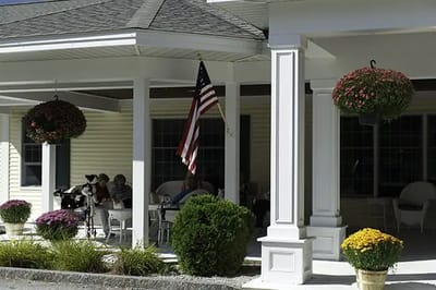 Front porch area with residents and flowers